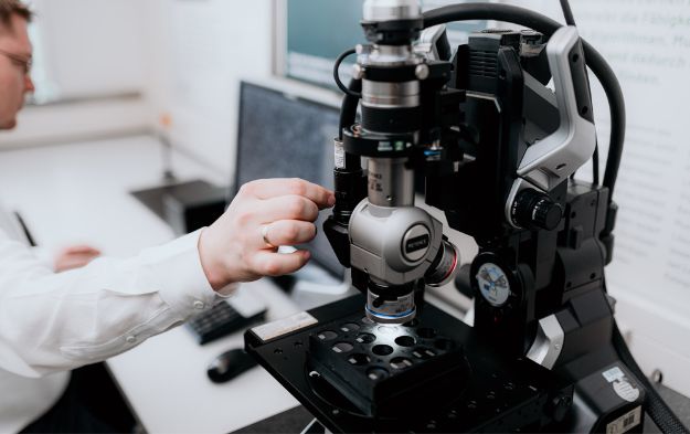 Man adjusting Kadence microscope. 